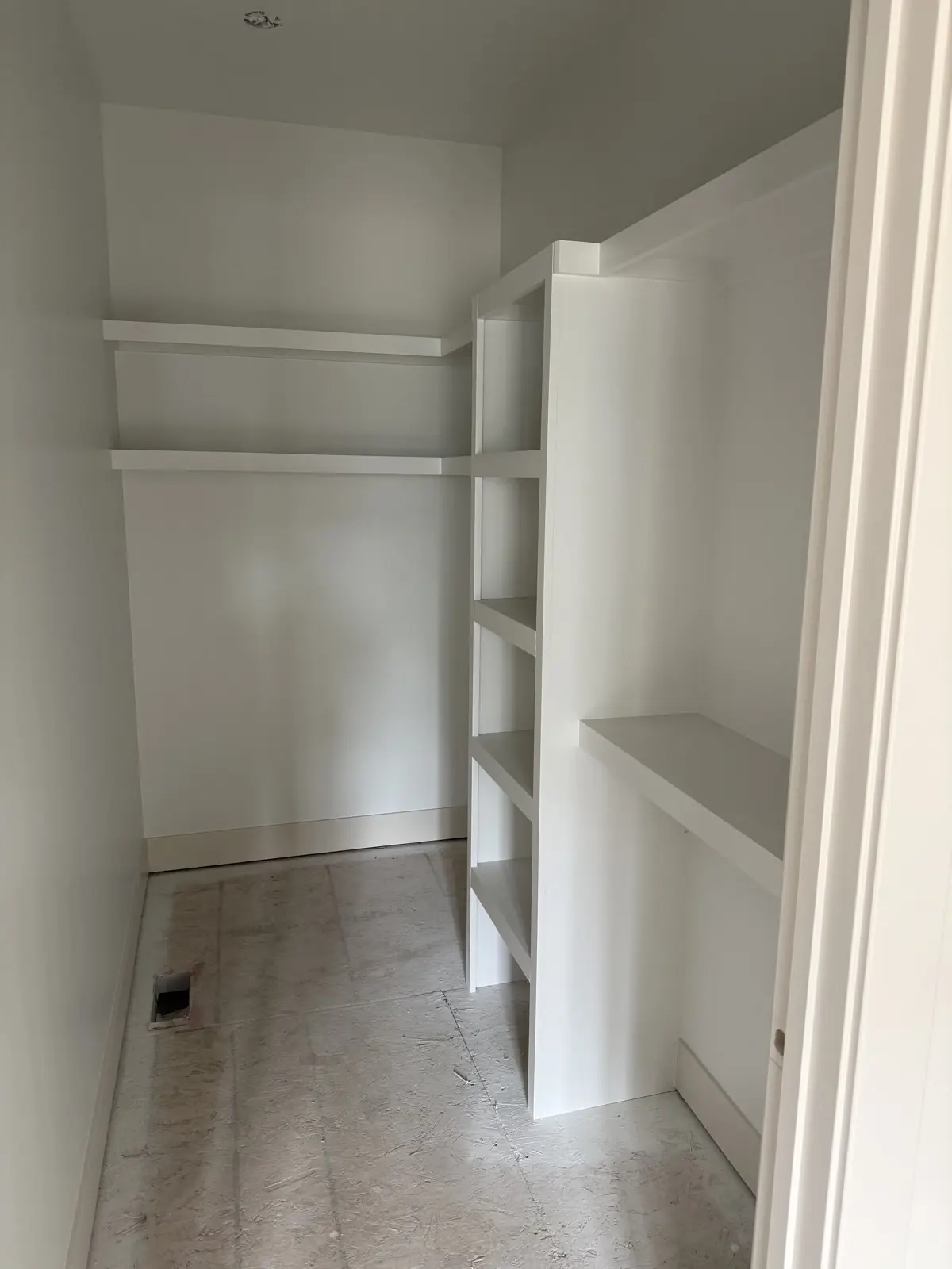 Finished white built-in shelving in a closet