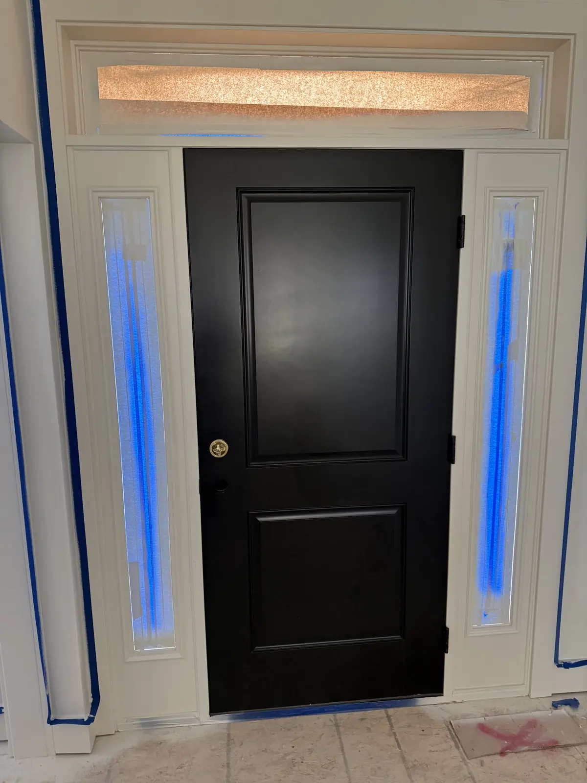 Black entry door with sidelights, masked with blue tape