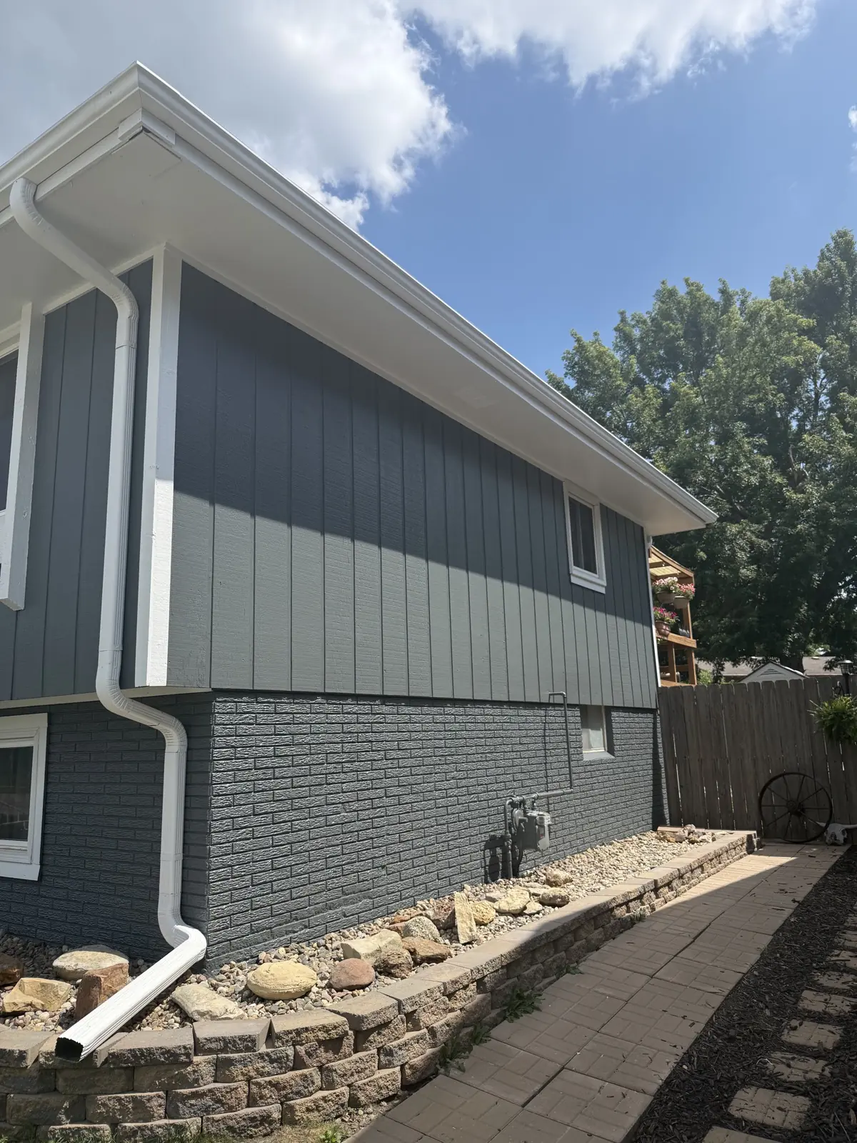 Gray painted house exterior with white trim and gutters