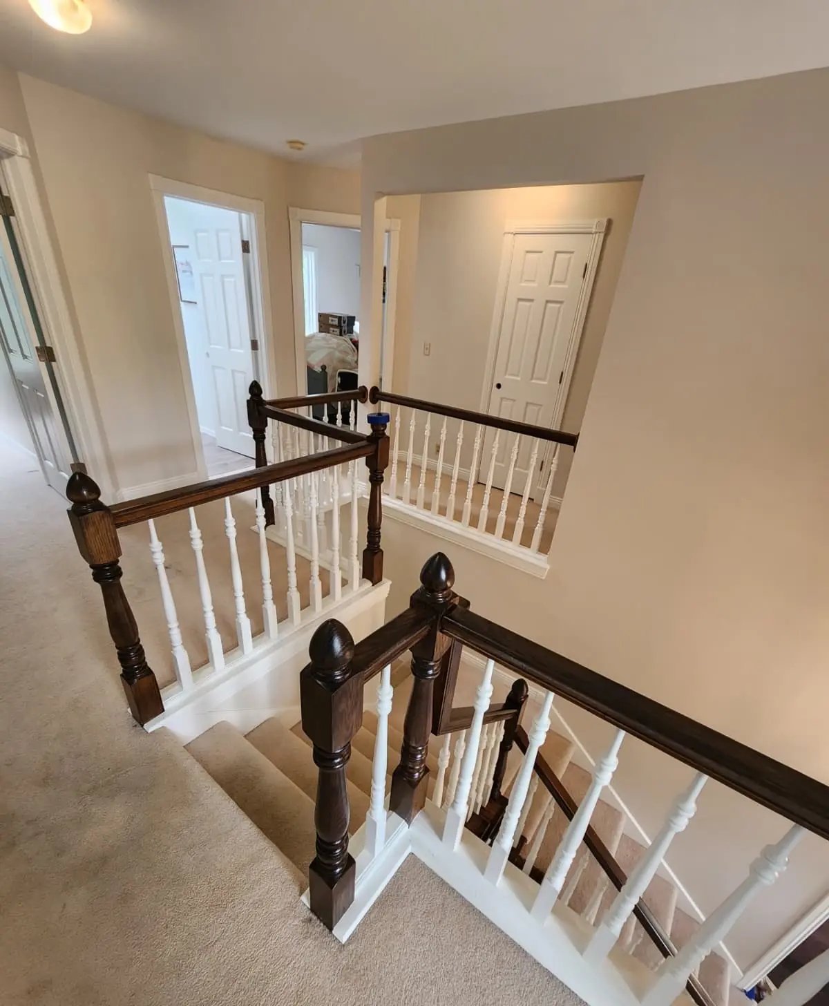 Interior staircase with a dark wood railing and white balusters