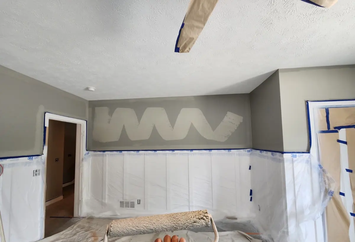 Wainscot masked with plastic and tape before painting